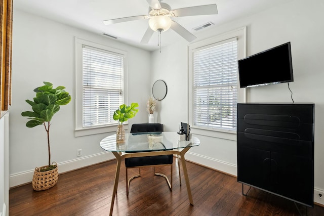 home office featuring a ceiling fan, wood finished floors, visible vents, and baseboards