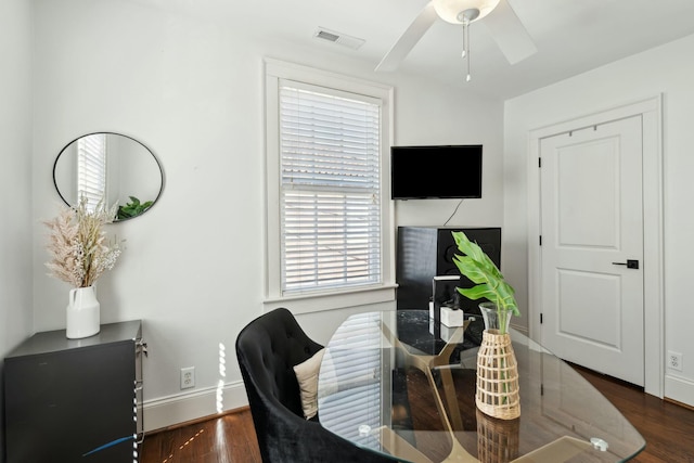 interior space featuring visible vents, baseboards, wood finished floors, and a ceiling fan