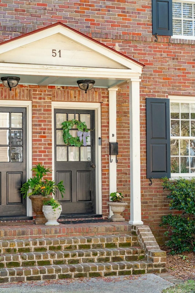 doorway to property featuring brick siding