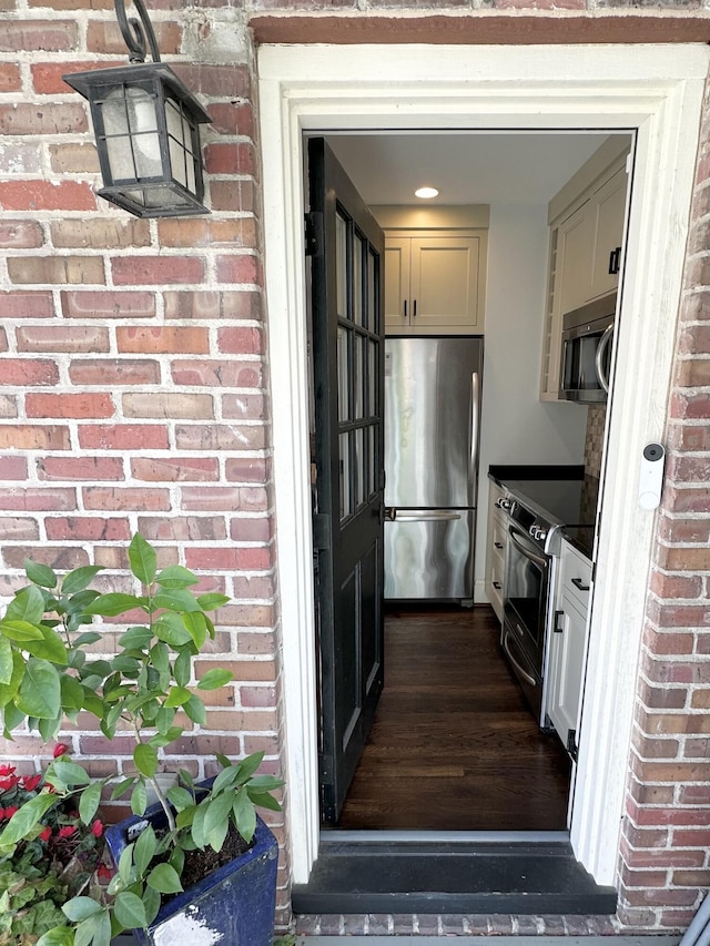 entrance to property featuring brick siding