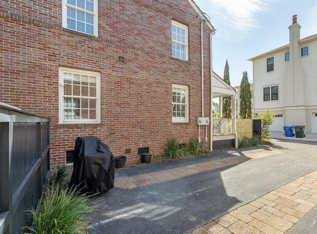 view of side of property featuring crawl space and brick siding