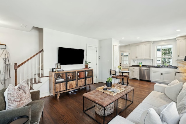 living room featuring stairway, recessed lighting, baseboards, and dark wood-style flooring