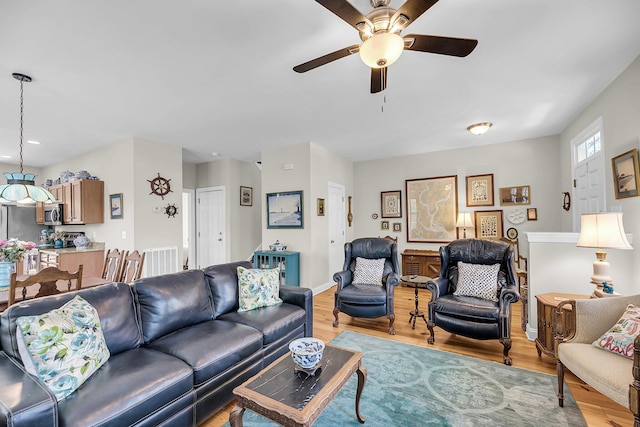 living room with light wood finished floors and ceiling fan