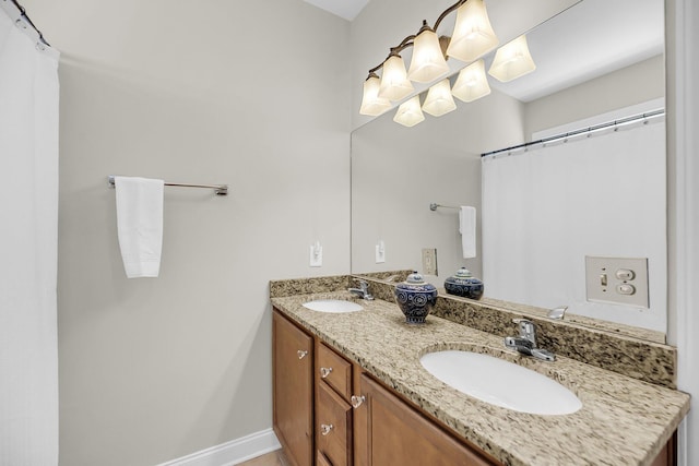 bathroom with double vanity, baseboards, and a sink