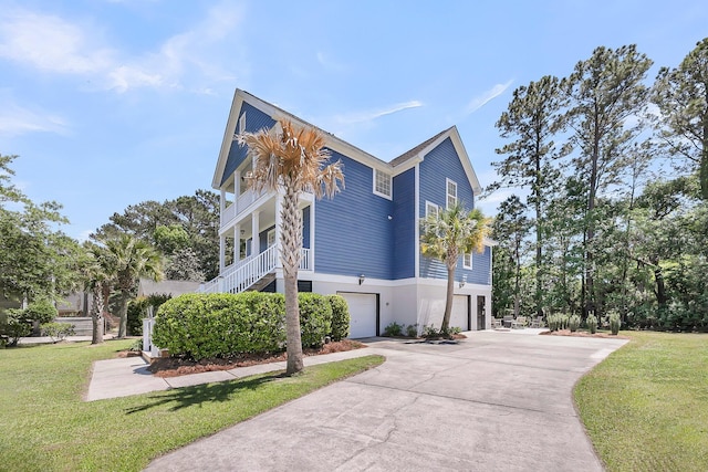 view of side of home featuring a lawn, an attached garage, driveway, and stairway