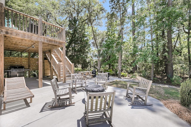 view of patio / terrace featuring a deck, a fire pit, and stairs