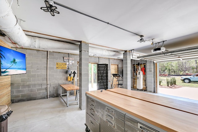 interior space with a garage door opener and concrete block wall