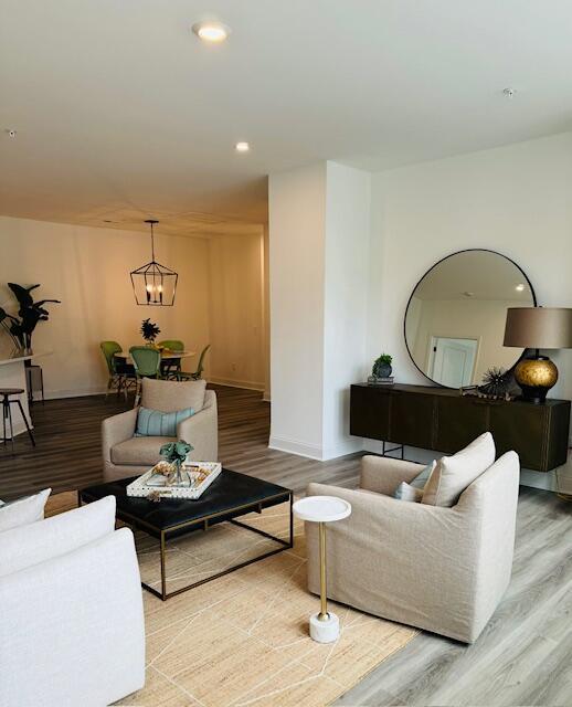 living room with light hardwood / wood-style floors and a chandelier