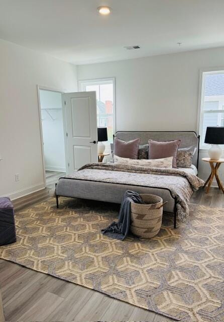 bedroom with multiple windows and hardwood / wood-style floors