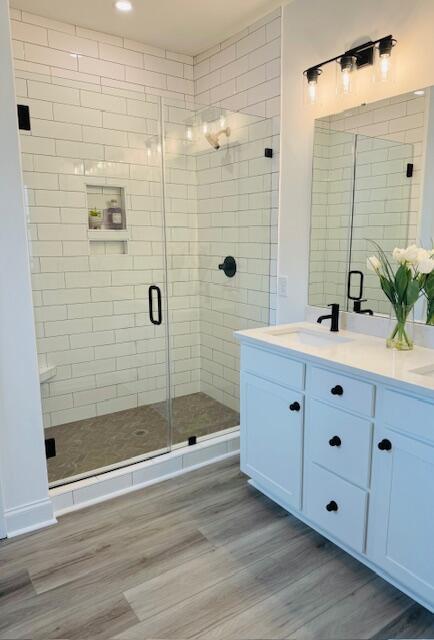 bathroom featuring vanity, walk in shower, and hardwood / wood-style floors