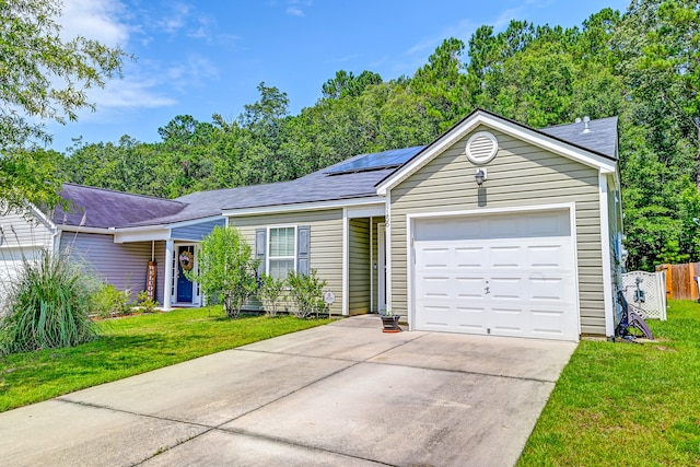 ranch-style home with a garage, a front lawn, and solar panels