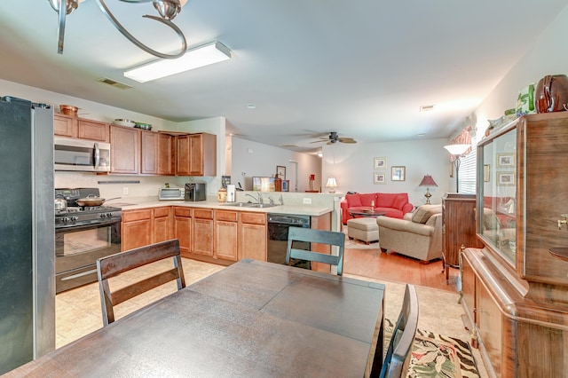 kitchen with sink, kitchen peninsula, ceiling fan, and black appliances