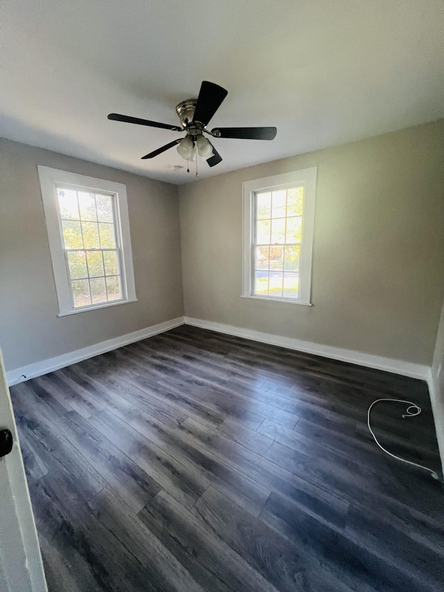 empty room with dark hardwood / wood-style flooring, ceiling fan, and a wealth of natural light