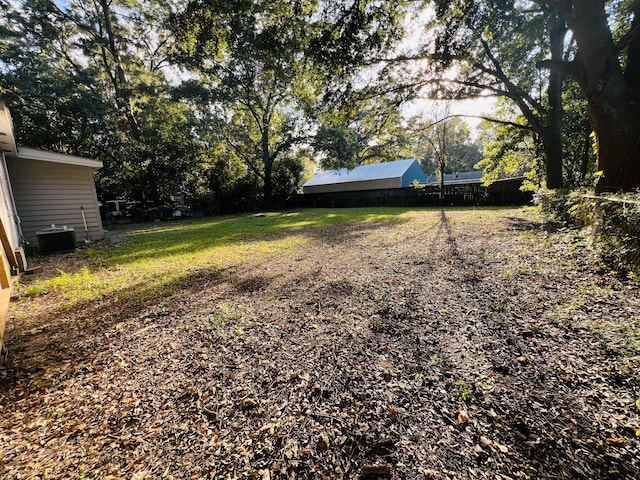 view of yard featuring central air condition unit and fence