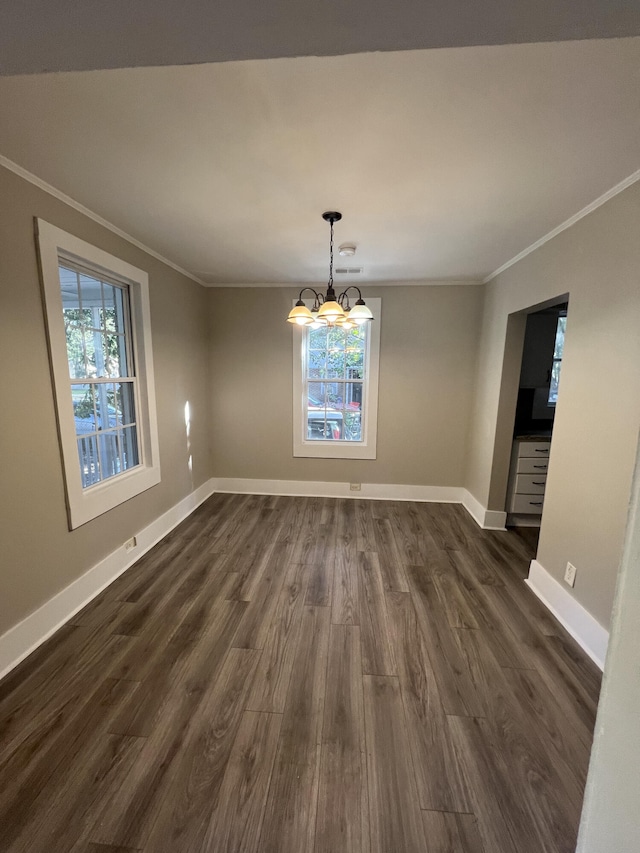 unfurnished dining area with baseboards, plenty of natural light, dark wood finished floors, and crown molding