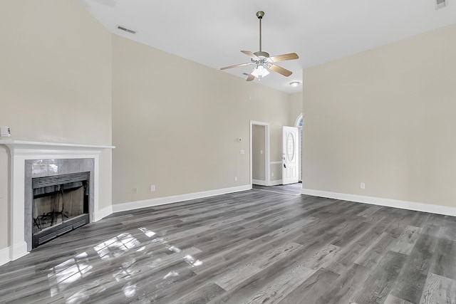 7869 High Maple Cir N, Charleston, SC 29418 - unfurnished living room featuring a ceiling fan, wood finished floors, a tile fireplace, a towering ceiling, and baseboards