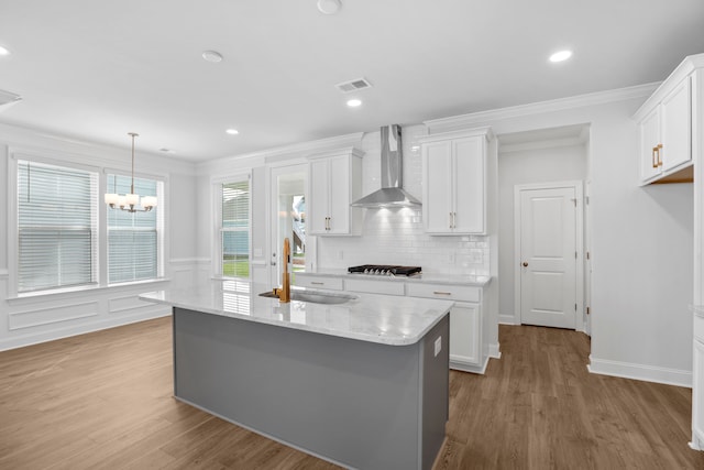 kitchen featuring white cabinets, hardwood / wood-style floors, and wall chimney exhaust hood