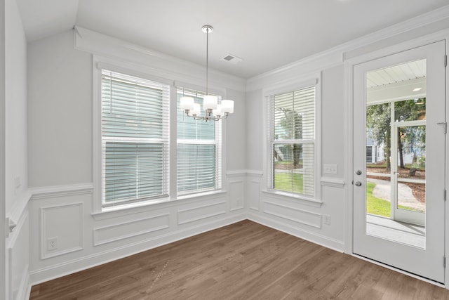 unfurnished dining area featuring hardwood / wood-style floors and a chandelier