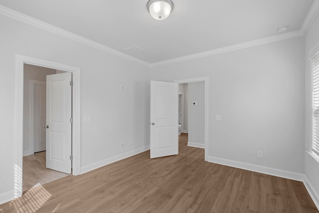 unfurnished bedroom featuring crown molding and light wood-type flooring