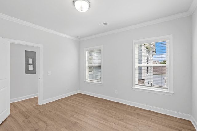 unfurnished room with electric panel, ornamental molding, a healthy amount of sunlight, and light hardwood / wood-style floors