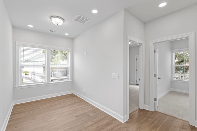 unfurnished room featuring light hardwood / wood-style flooring and plenty of natural light