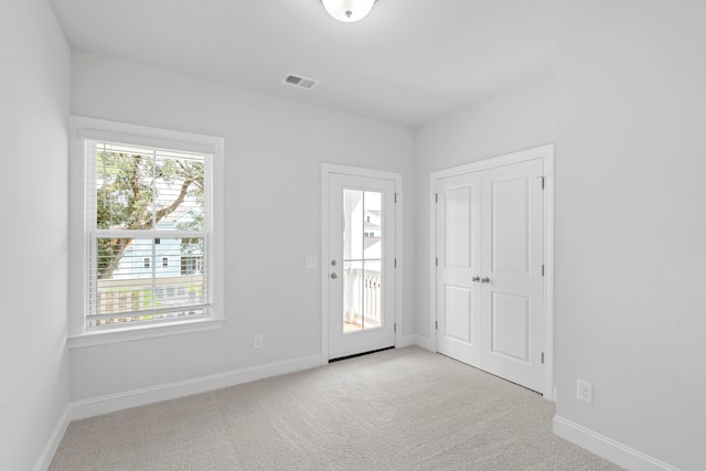 interior space featuring light carpet and a healthy amount of sunlight