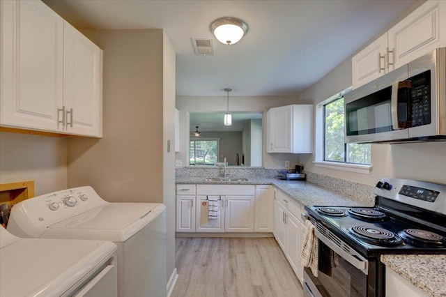 8483 Yadkin Cir Unit D, North Charleston, SC 29406 - kitchen with appliances with stainless steel finishes, washing machine and dryer, light wood finished floors, and white cabinetry