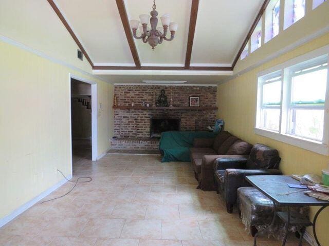 living room featuring light tile floors, a notable chandelier, a fireplace, brick wall, and lofted ceiling with beams