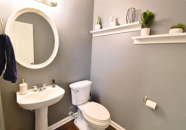 bathroom featuring baseboards, toilet, and wood finished floors