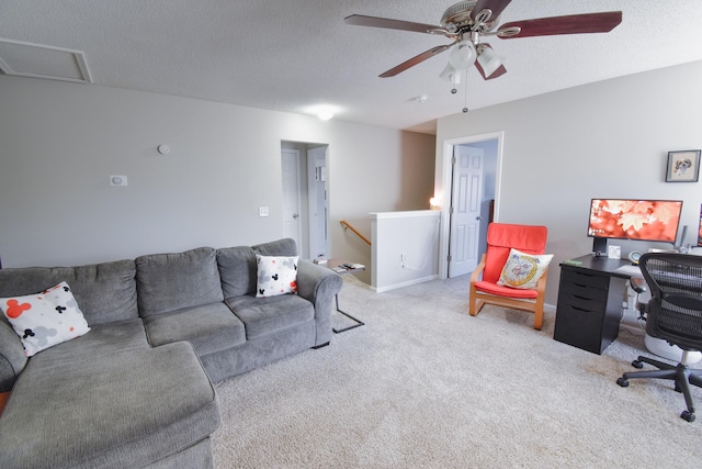 living room featuring attic access, a textured ceiling, baseboards, and carpet flooring