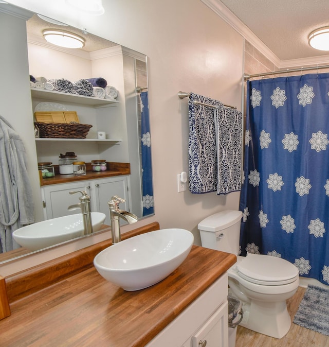 bathroom with crown molding, toilet, vanity, a textured ceiling, and wood finished floors