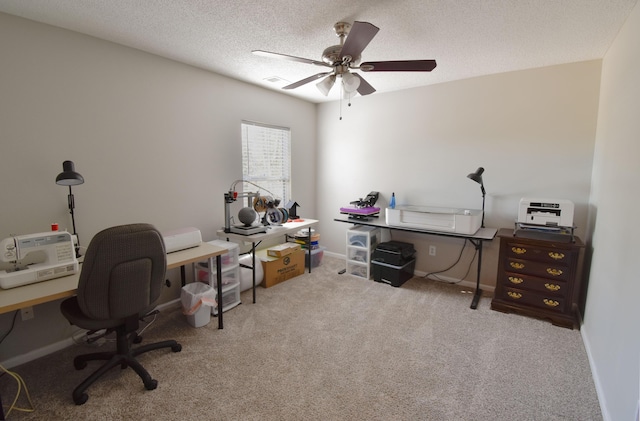 office space featuring carpet floors, a textured ceiling, baseboards, and a ceiling fan