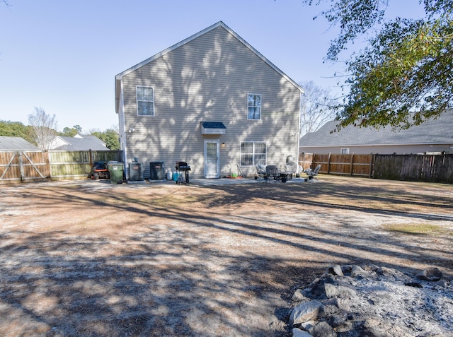 back of house with a patio area, a fenced backyard, and central AC