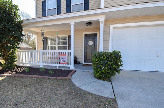 doorway to property with a garage and covered porch