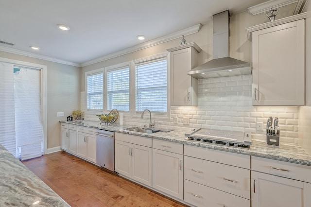 kitchen with wall chimney exhaust hood, decorative backsplash, light wood-type flooring, stainless steel appliances, and white cabinets