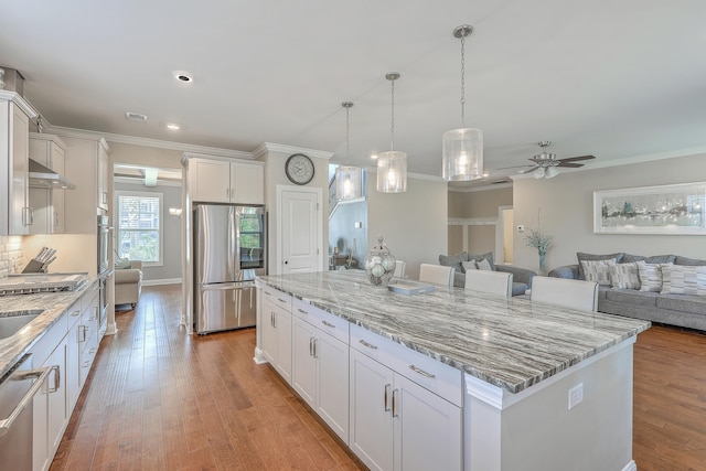 kitchen featuring a kitchen island, light hardwood / wood-style floors, white cabinetry, and stainless steel appliances