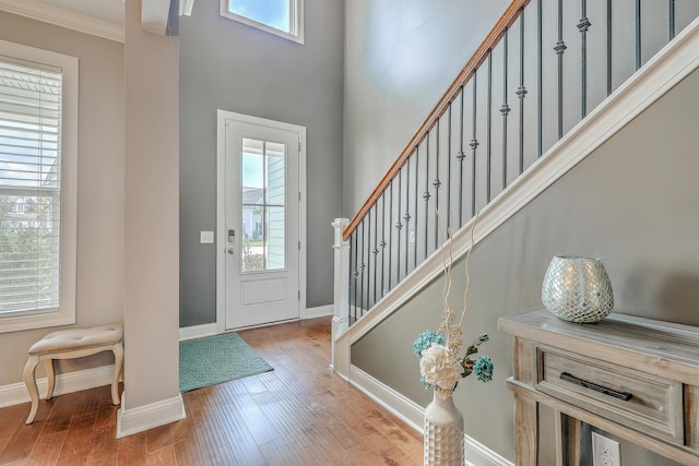 entrance foyer featuring ornamental molding and light hardwood / wood-style floors