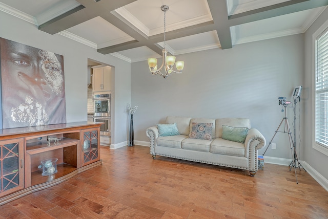 living room featuring light hardwood / wood-style floors, an inviting chandelier, crown molding, coffered ceiling, and beam ceiling