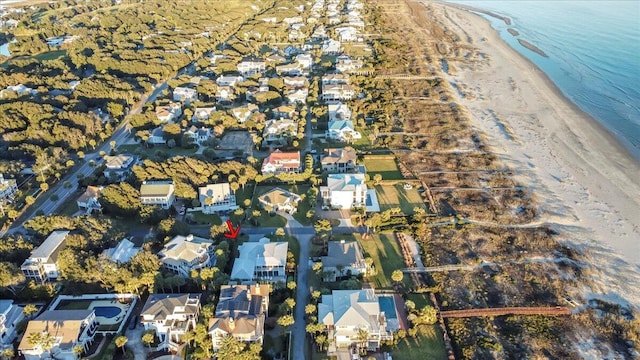 birds eye view of property with a water view and a beach view