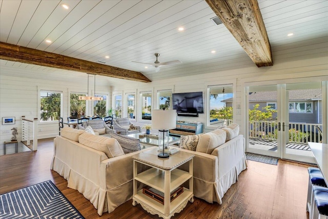 living room with beam ceiling, plenty of natural light, and hardwood / wood-style floors