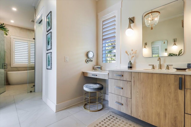 bathroom with vanity, an inviting chandelier, and a bath