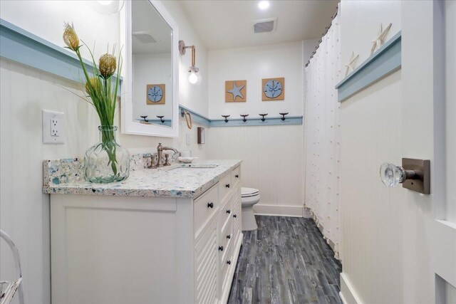 bathroom featuring wood-type flooring, toilet, and vanity