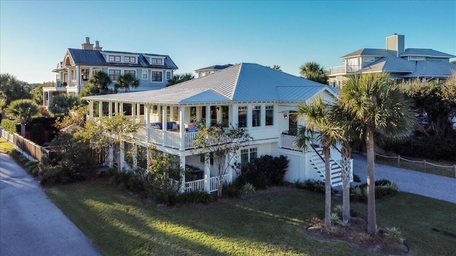 rear view of property with a balcony and a lawn