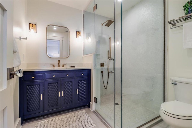 bathroom with toilet, vanity, walk in shower, and tile patterned flooring