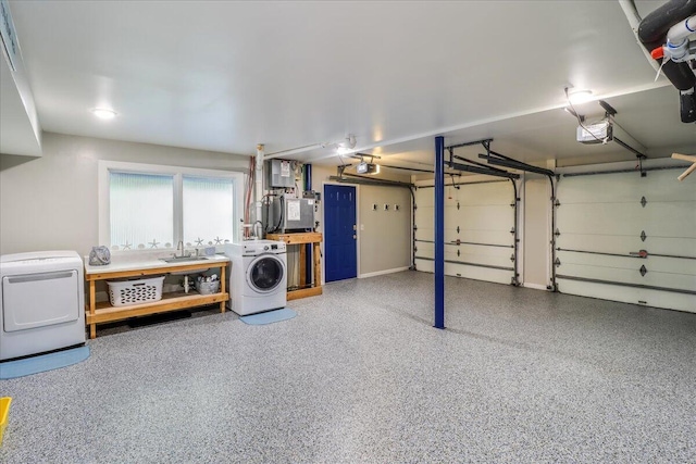 garage with a garage door opener, washer / clothes dryer, and sink