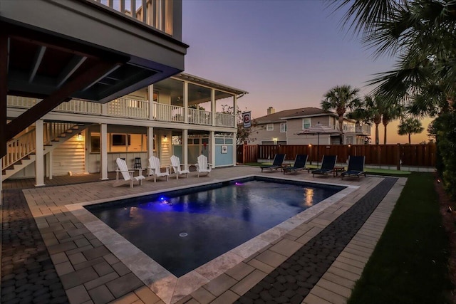 pool at dusk featuring a patio area