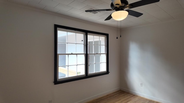 empty room featuring ceiling fan, light wood-type flooring, and crown molding