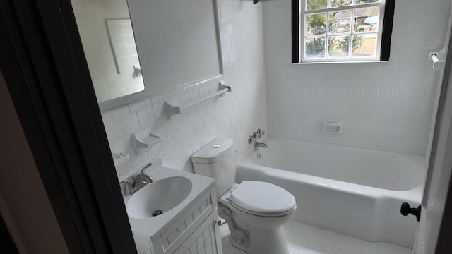 full bathroom with tile patterned floors, toilet, vanity, tile walls, and tiled shower / bath