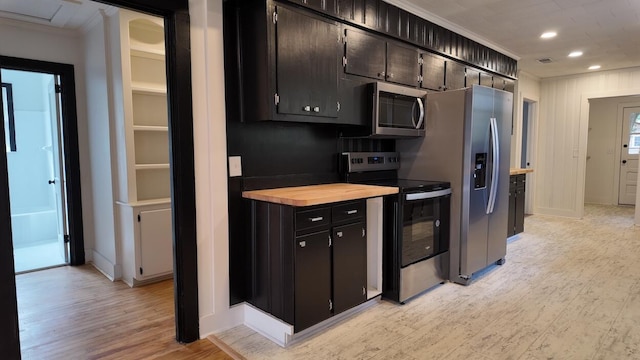 kitchen featuring light hardwood / wood-style floors, butcher block counters, and stainless steel appliances