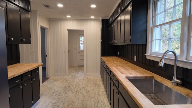 kitchen featuring butcher block countertops, light hardwood / wood-style floors, and sink